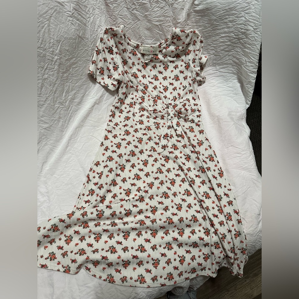 A flower dress. It’s white, there are pink detailed flowers and leaves on them.